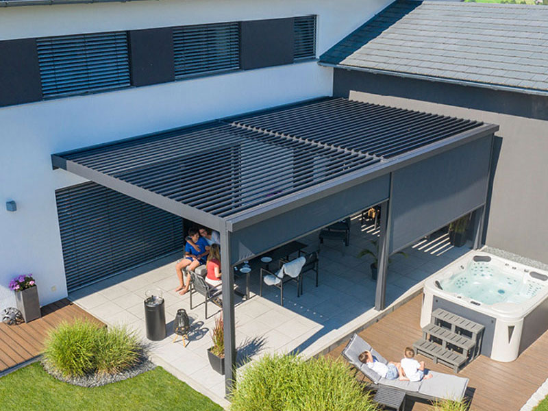 Schwarzes Lamellendach über einer Terrasse mit senkrechten