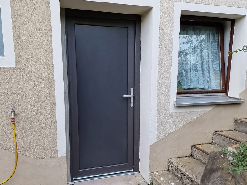 Anthrazite Nebeneingangstür als Kellereingang mit silbernen Griff