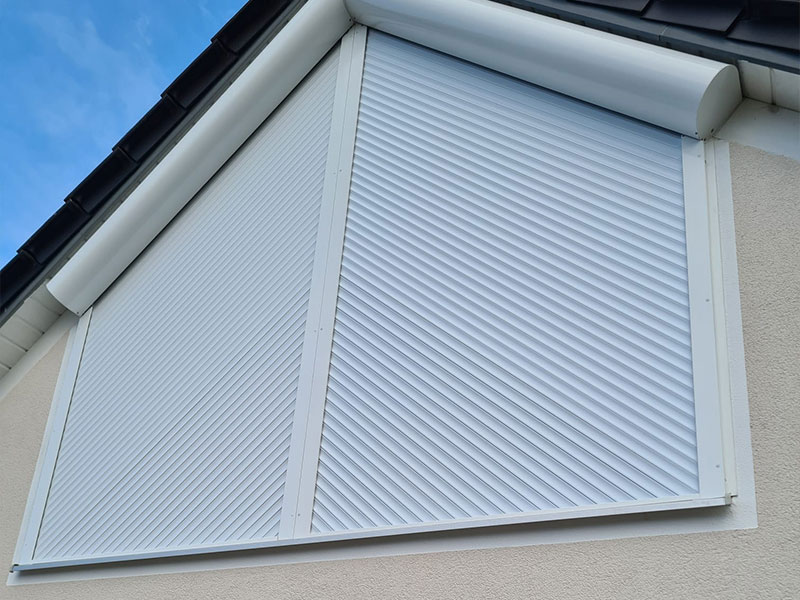 Weiße Schrägrollladen für ein Giebelfenster