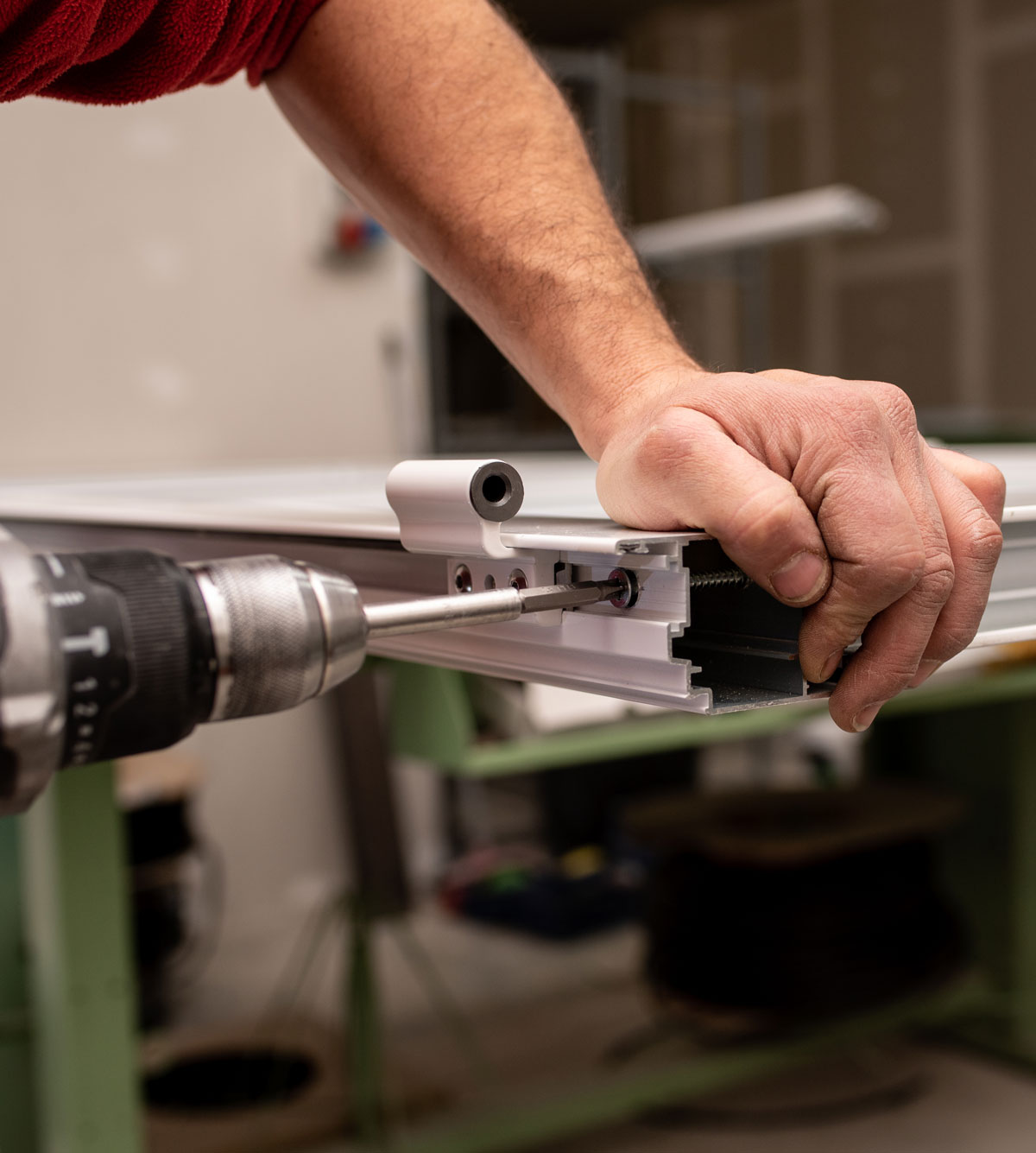 male-with-red-shirt-making-window-with-industrial-tools